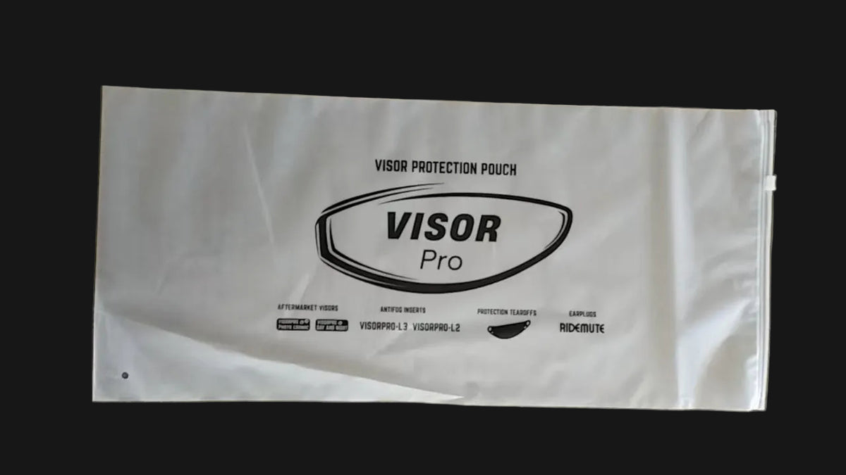 A white plastic visor protection pouch with black printed branding and text, laid flat on a gray concrete floor.